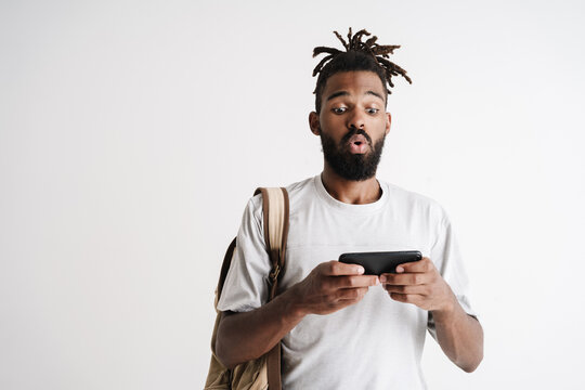 Photo of surprised african american guy playing online game on cellphone