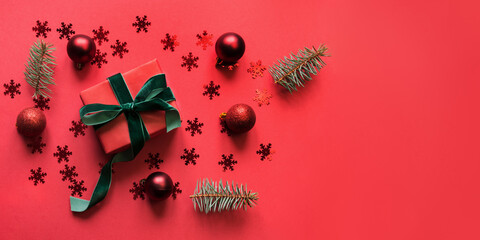 Christmas banner with red holiday gift, baubles on red background. Xmas greeting card with copy...