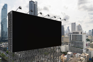 Obraz premium Blank black road billboard with Bangkok cityscape background at day time. Street advertising poster, mock up, 3D rendering. Side view. The concept of marketing communication to promote or sell idea.