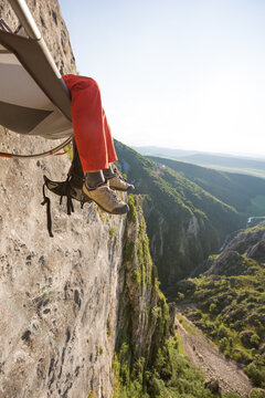 Climber sitting in his portaledge high up above the ground