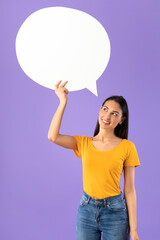 Portrait of thinking woman holding speech bubble
