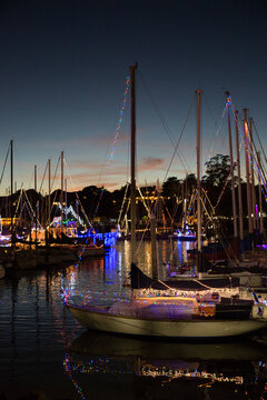 Boats in a harbor decorated with lights for Christmas