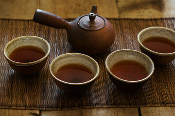 Four clay cups and teapot of traditional eastern tea