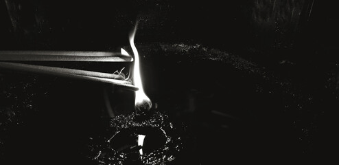Close up burning incense inside oil lamp to worship Buddha images at a Thai temple in black and white tone. Region, Faith, Belief and Buddhist concept.