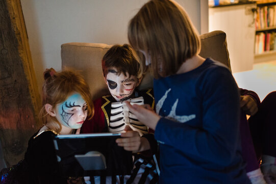 Halloween children gathered around a tablet computer