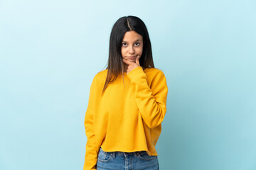 Caucasian girl isolated on blue background thinking