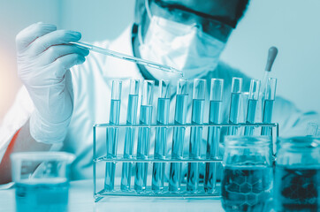 Scientist hand holding pipette dropping a sample into a test tube and science experiments ,Laboratory glassware containing chemical liquid,