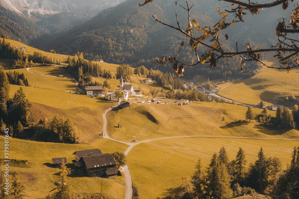 Sticker Aerial shot of a  beautiful village on a hill surrounded by the mountains during daylight