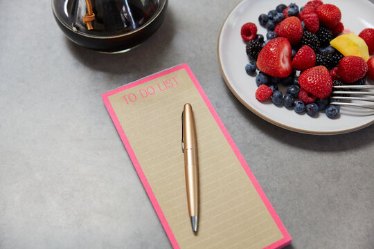 To do list and pen on kitchen counter with breakfast