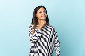 Caucasian girl isolated on blue background and looking up
