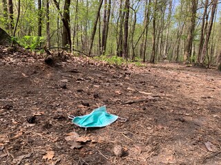 Used medical mask at forest. Covid-19 contributes to environmental pollution. Environmental problem after the coronavirus epidemic. COVID and Single-Use Plastics, environmental crisis