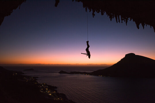 Man hanging upsidedown from a rope
