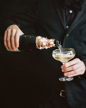 man pours champagne