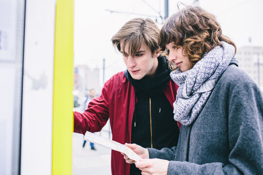 Young couple looking at the bus timetable