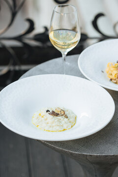 Plate of italian truffel risotto and a glass of white wine