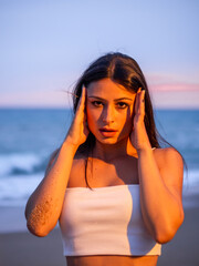 Mujer joven posando en la playa durante el atardecer