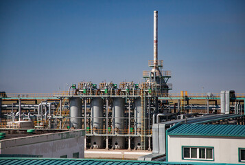 Oil refinery plant close-up. Pipelines and columns on blue sky background. Petrochemical industry.