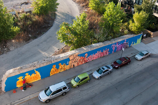 artist works on an urban mural