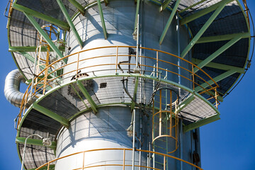 Petrochemical plant. Close-up of Oil distillation tower (refining column)  on blue sky.