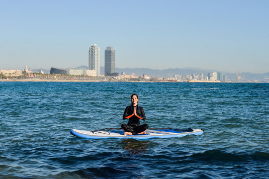 Female sitting on surf in prayer pose
