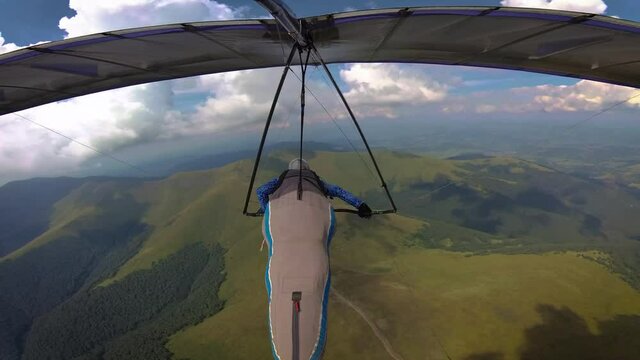 Hang glider pilot races high in the mountains. On board video of extreme sport.