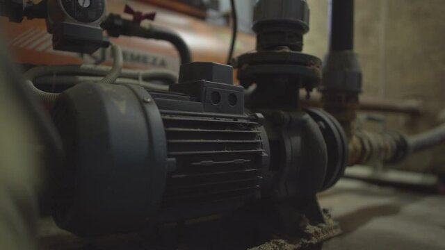 Part of compressor system equipment on plant or factory producing concrete. Close-up of pump unit for valves opening on cement manufacturing site.