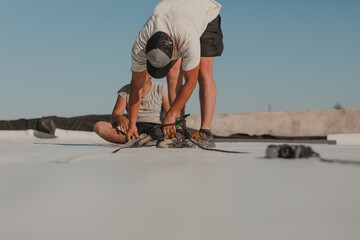 Worker welding pvc roof membrane by heater with welder machine