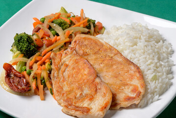 Grilled chicken breast with rice and vegetable salad.