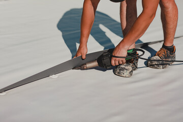 Worker welding pvc roof membrane by heater with welder machine © Doralin
