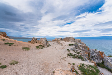 Fototapeta na wymiar Landscape with Burkhan cape against the backdrop of a blu sky and lake. Olkhon Island, Lake Baikal.