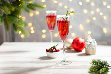 Mimosa festive drink for Christmas - champagne red cocktail Mimosa with cranberry for Christmas party, copy space