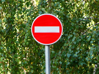Traffic sign No entry or Wrong way prohibitory on the street with tree background