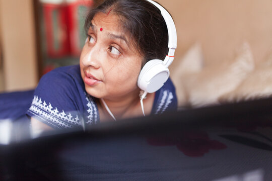 Indian woman enjoying music using headphone