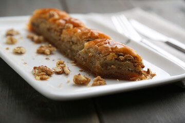 Baklava with walnut on a white plate close up