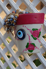 Decorative plant pot with Evil Eyes of a wall background in village Kas, Turkey