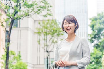 オフィス街で微笑む若い女性