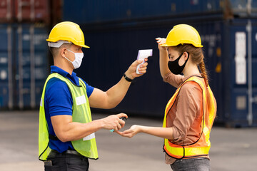 Foreman uses thermometer measuring temperature to check worker and use sanitizer alcohol gel...