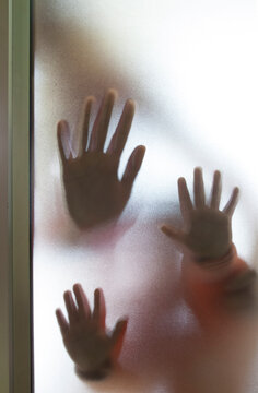 Three Hand impression behind opaque and frosted glass
