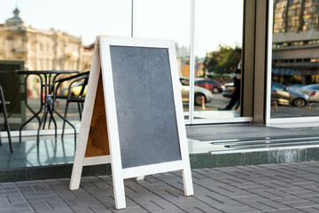 Signboard on the street. Empty menu board stand. Restaurant sidewalk chalkboard sign board....