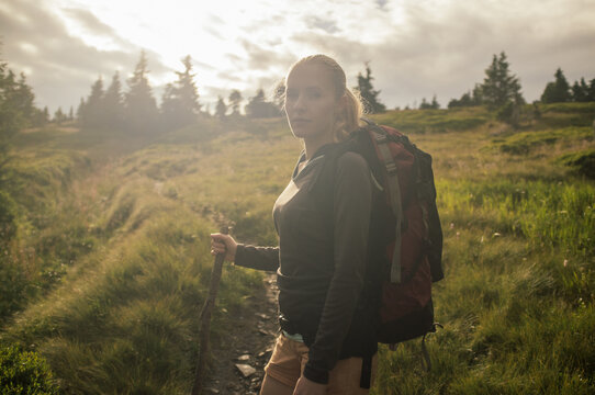 Young caucasian woman walking on the hilltop of european mountai
