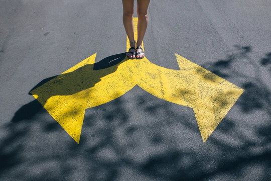 Girl standing on two arrows, making a choice