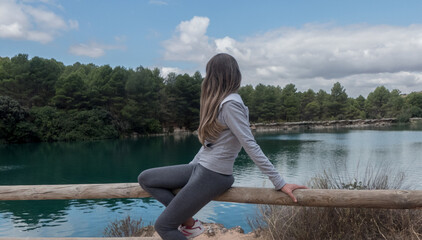 Mujer relajándose observando el horizonte de un hermoso lago