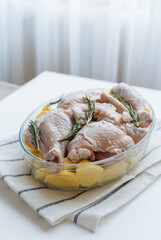 Chicken with potatoes and rosemary in a glass bowl
