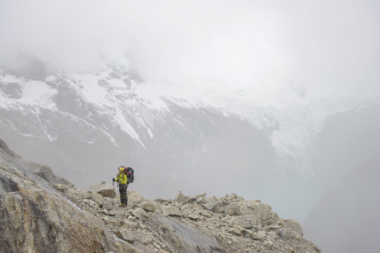 Mountain climber ascending on craggy cliff in Cordillera Blanca,