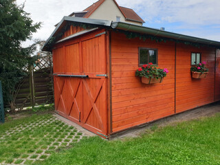 Gemütliches Gartenhaus Holzhütte mit Blumen im Grünen