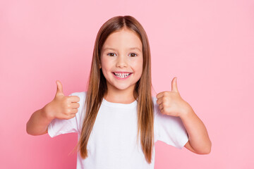 Photo of positive cheerful kid girl show thumb up sign enjoy new school ads adverts wear white...