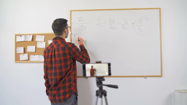 Math professor at home, looking and talking direct to camera during online classroom session