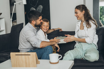 family sharing gifts, sitting on sofa at home