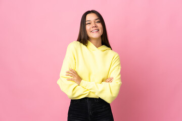 Teenager girl isolated on pink background keeping the arms crossed in frontal position