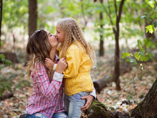 Loving young mother, having fun in nature with her child, in the fall. Emotion concept. Psychology.